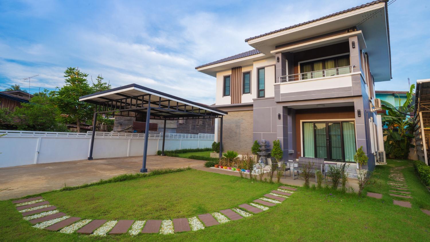 Modern two-storey house with lawn, stepping-stone path and open carport